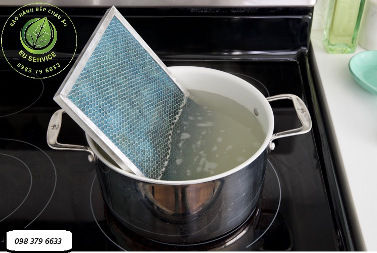 vệ sinh lưới lọc hút mùi bằng đun nước nóng và bột backing soda